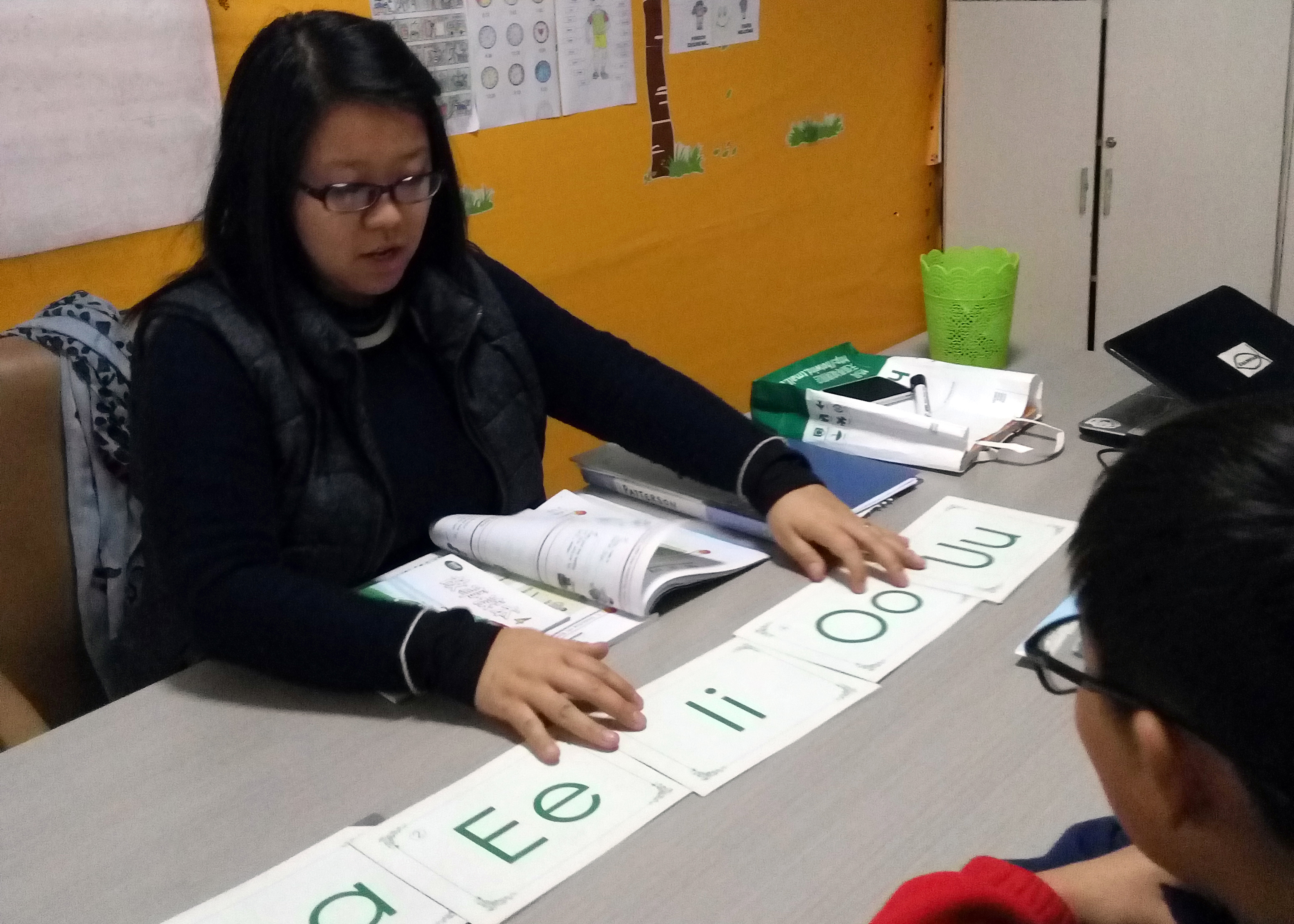 Mrs. Patterson teaching a student english vowels