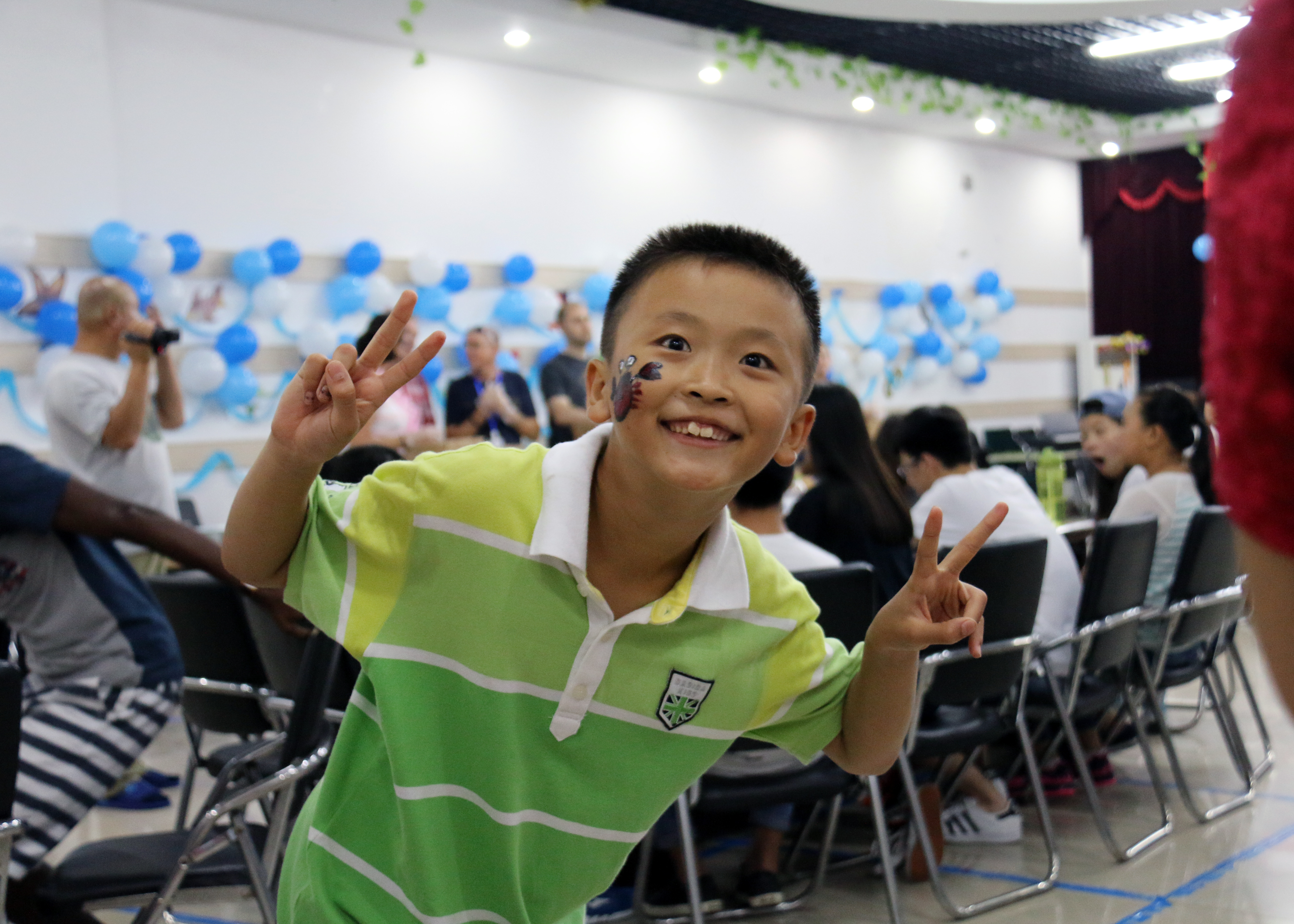 A child with face paint at a party.